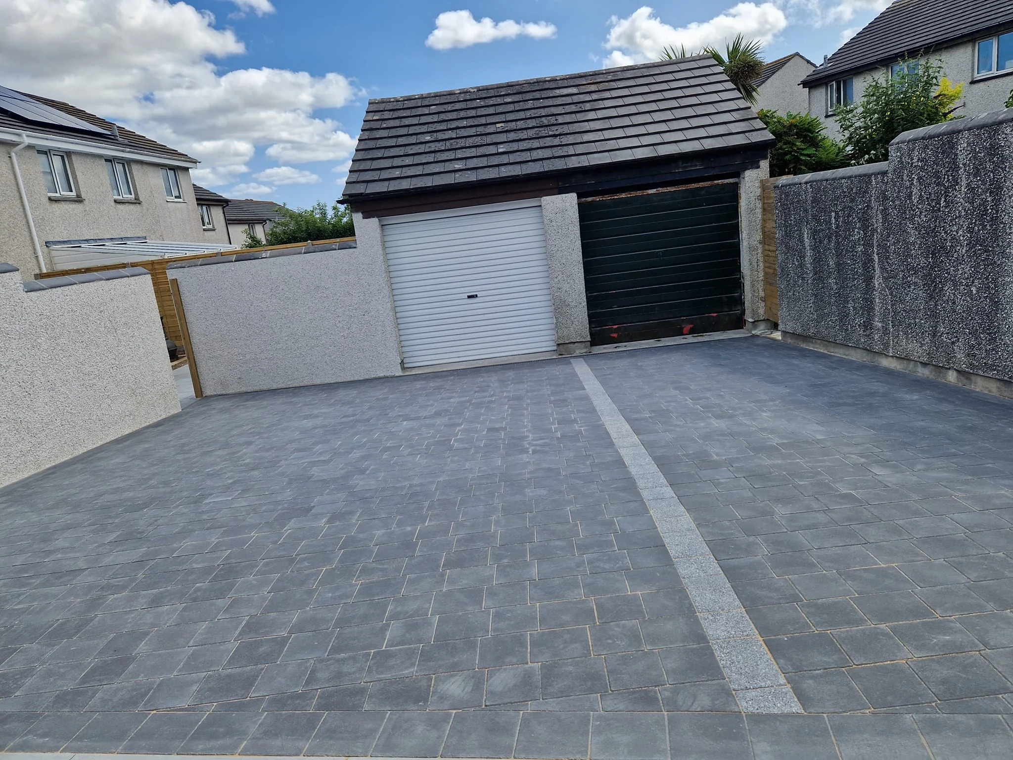 Block paved driveway leading to a garage