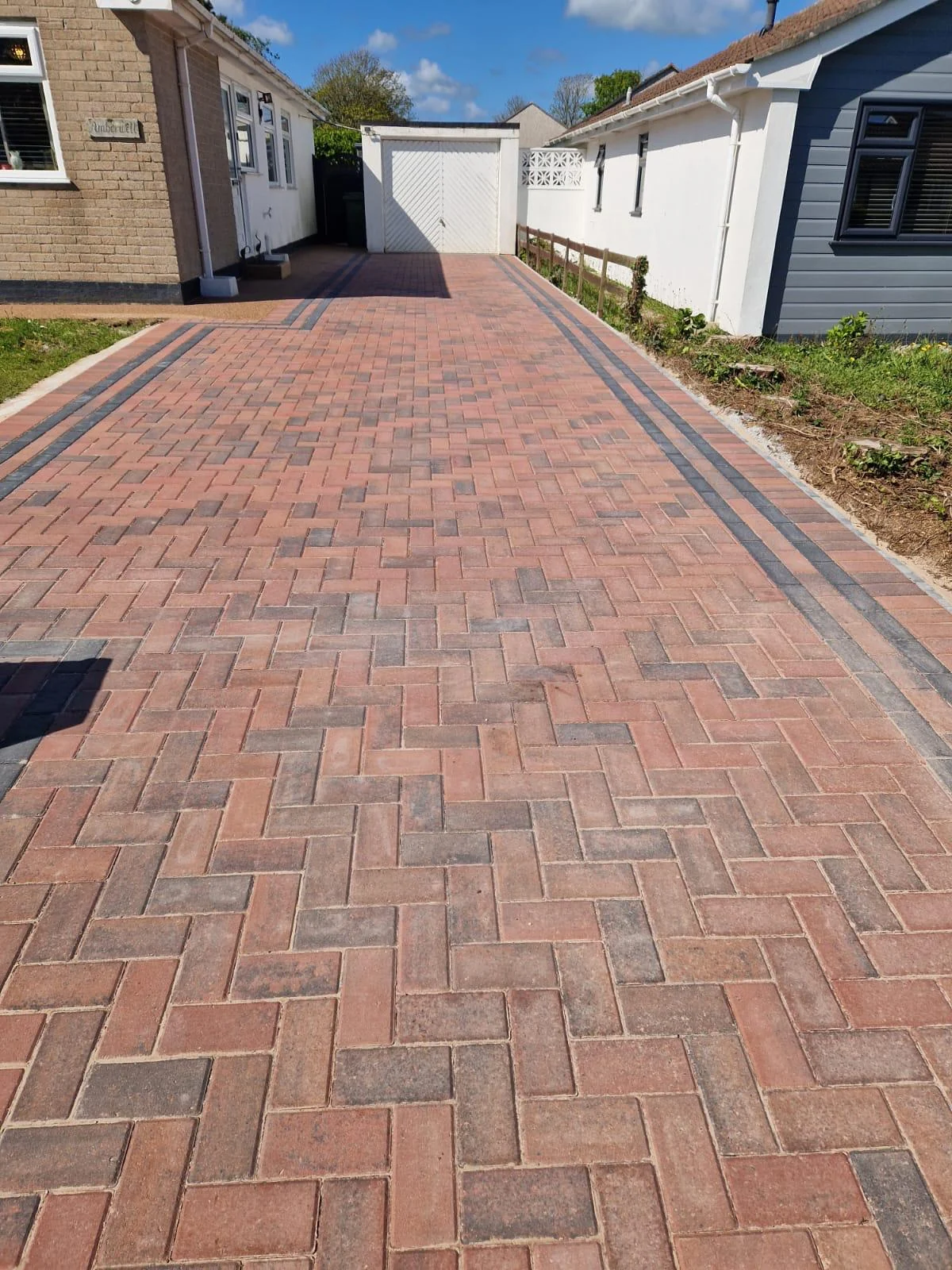 Red block paved driveway in a herringbone pattern