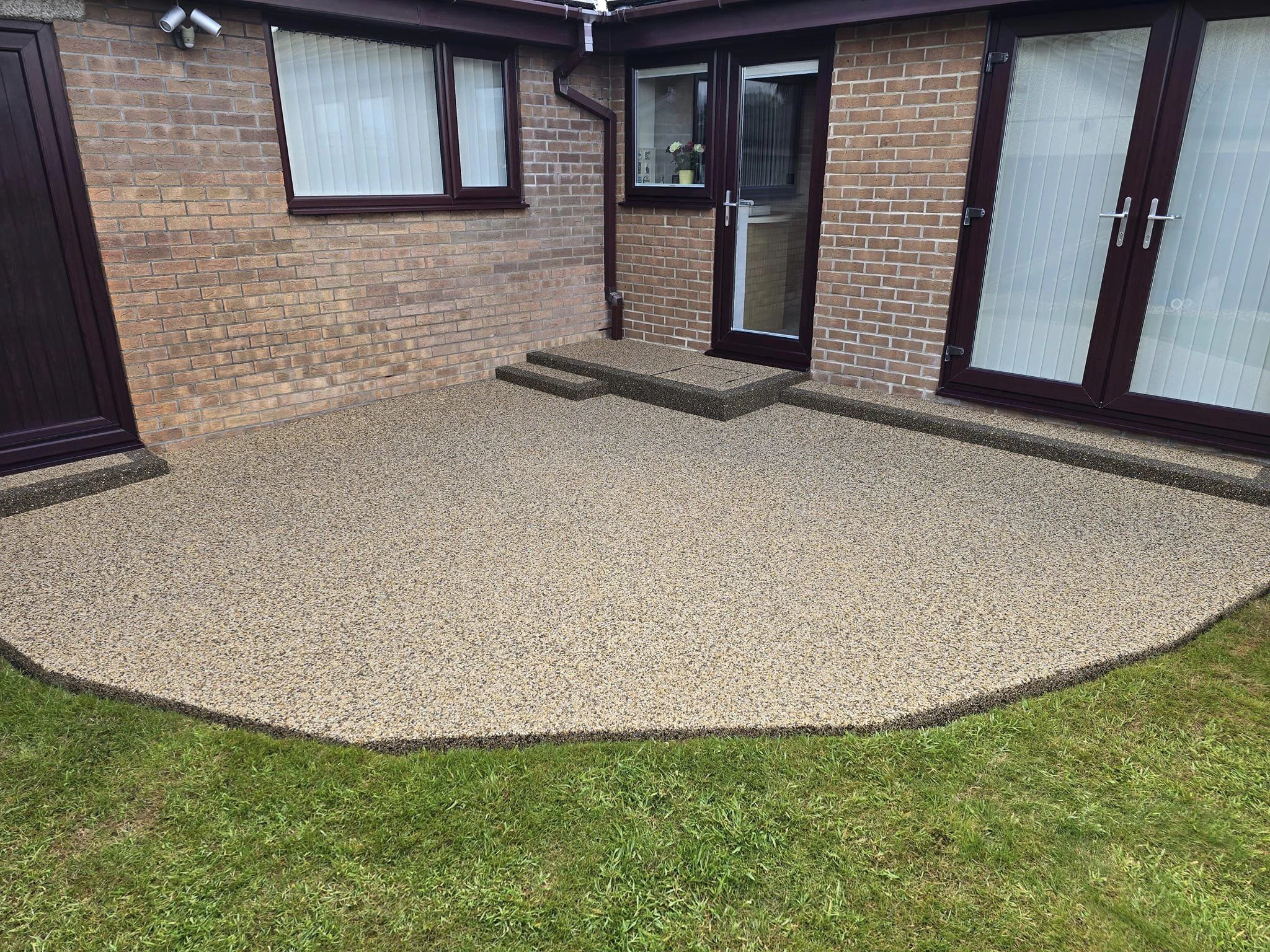 Resin bound patio with a curved lawn edge