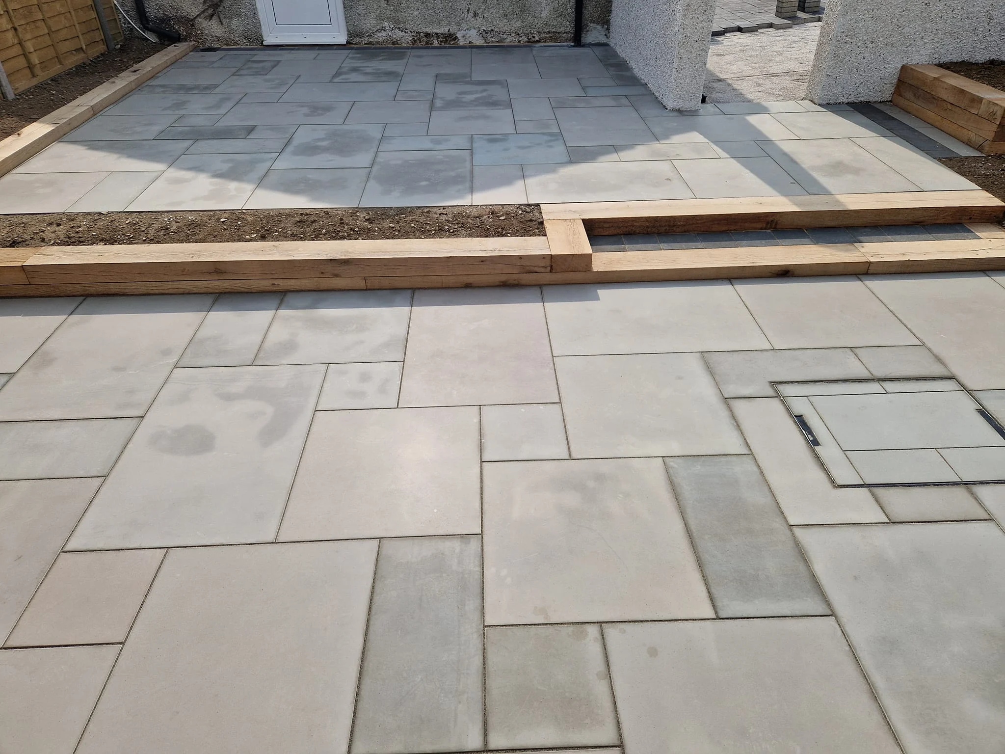 Sandstone patio edged with timber sleepers
