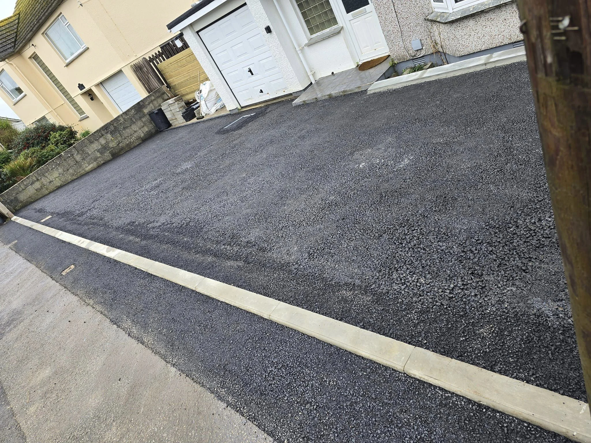 The same driveway relaid in tarmac with a new kerb edge